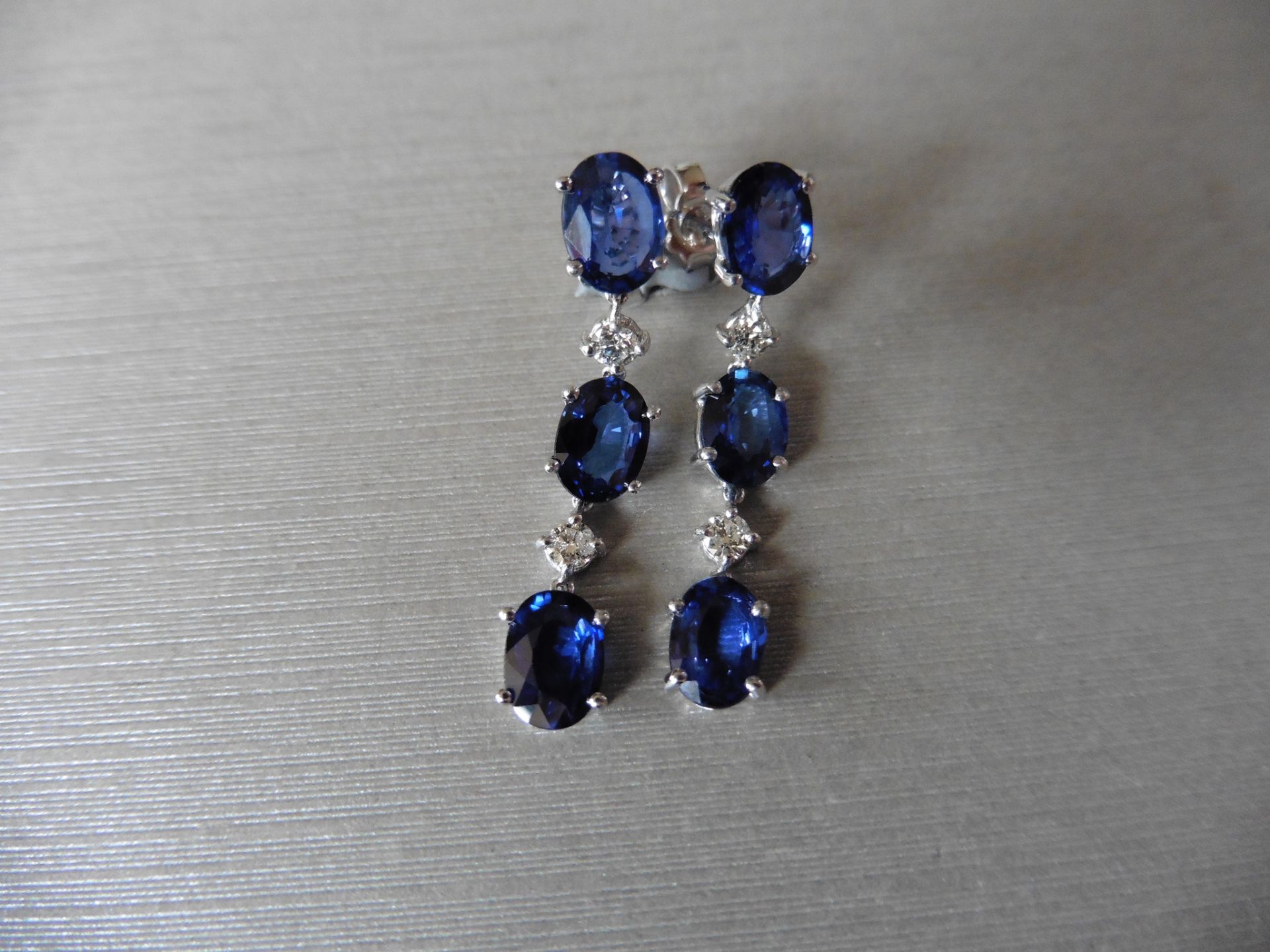 4.80ct sapphire and 0.12ct diamond drop earrings. Each set with 3 oval cut sapphires and 2 brilliant