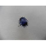 6ct sapphire and diamond cluster ring. Oval cut colour treated sapphire surrounded by brilliant