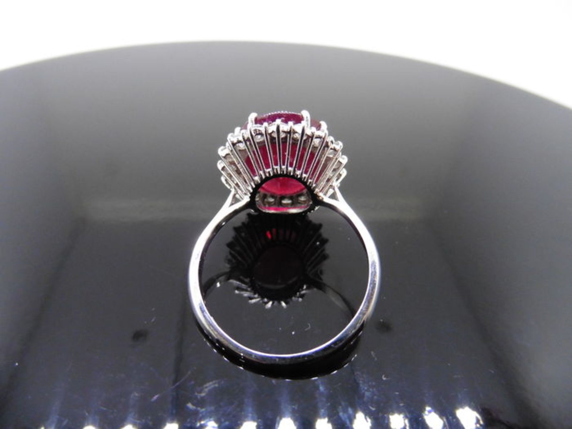 12ct ruby and diamond cluster ring. Oval cut ruby in the centre surrounded by brilliant cut - Image 4 of 4