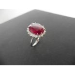 12ct ruby and diamond cluster ring. Oval cut ruby in the centre surrounded by brilliant cut