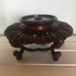 Chinese carved hardwood lotus leaf design vase stand of circular form on four legs with under-