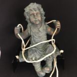 Bronze finished composite garden statue of a girl on a swing, measuring 31cm head to toe. Includes