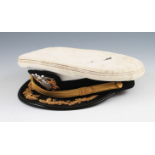 A US NAVY OFFICER'S PEAKED CAP WITH CAP TO FRONT AND GOLD TONE EMBROIDERY. - This lot is offered