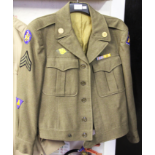 A US WW2 TUNIC WITH MEDAL BAR AND CLOTH BADGES TO ARMS, DATED JUNE 9TH 1944.