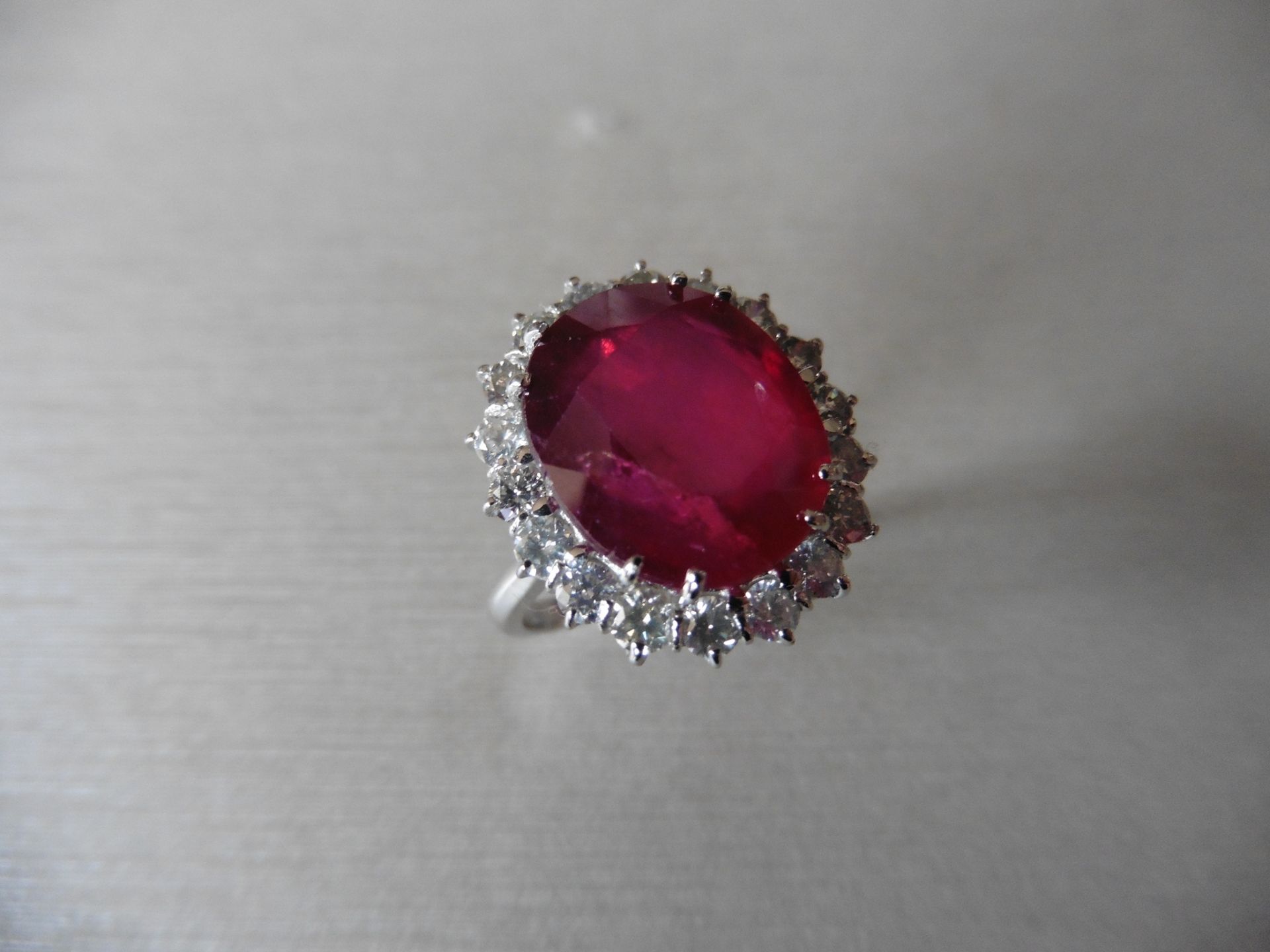 8ct ruby and diamond cluster ring. Oval cut ruby in the centre surrounded by brilliant cut diamonds,