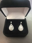2.04ct diamond drop earrings. Each set with a certificated pear shaped diamond with a halo setting.