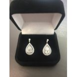 2.04ct diamond drop earrings. Each set with a certificated pear shaped diamond with a halo setting.