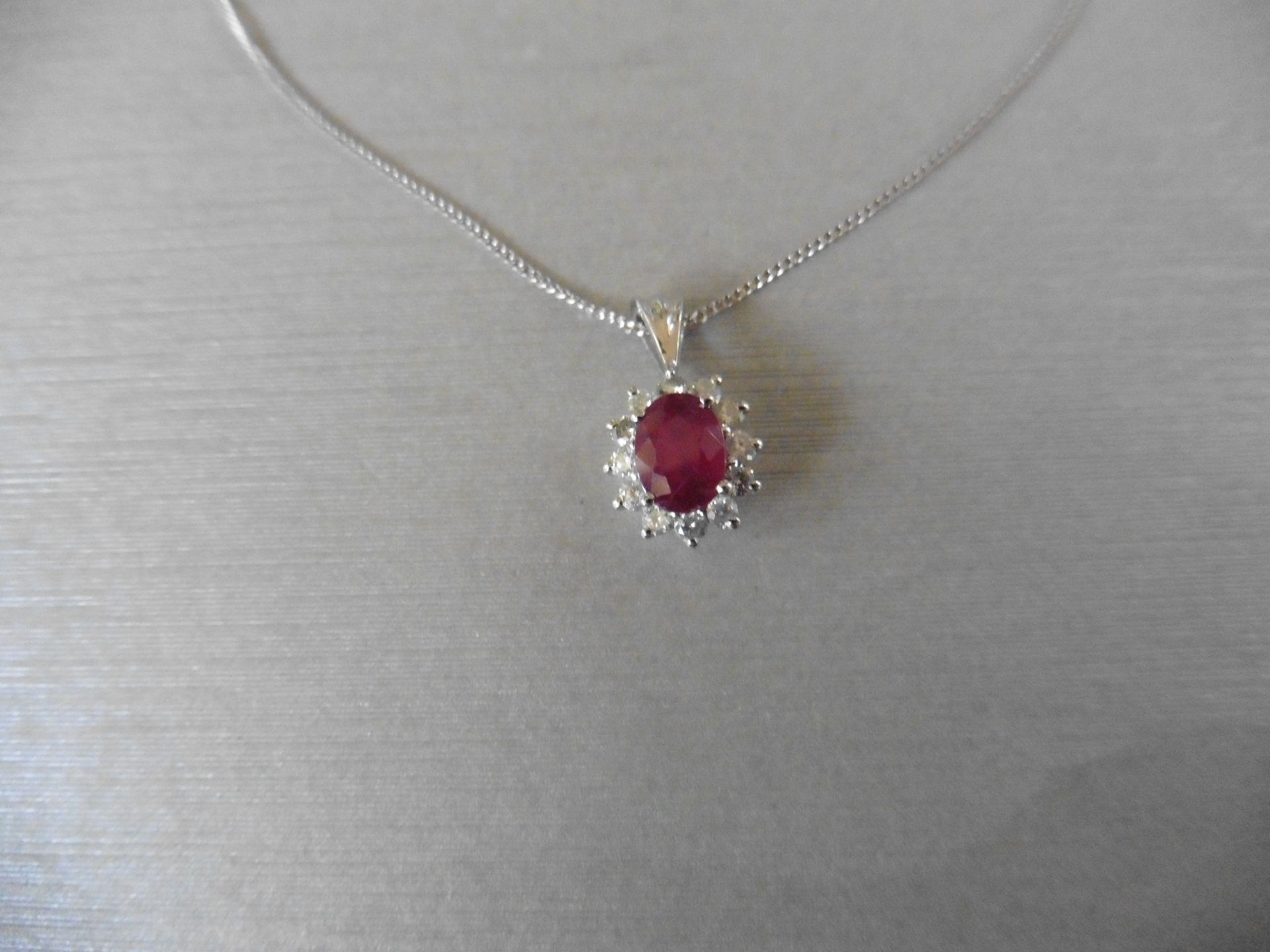 0.80ct ruby and diamond cluster style pendant.  Oval cut ( glass filled ) treated ruby with 12 small