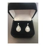 2.04ct diamond drop earrings. Each set with a certificated pear shaped diamond with a halo