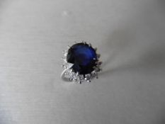 6ct sapphire and diamond cluster ring. Oval cut colour treated sapphire surrounded by brilliant