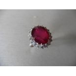 8ct ruby and diamond cluster ring. Oval cut ruby in the centre surrounded by brilliant cut diamonds,