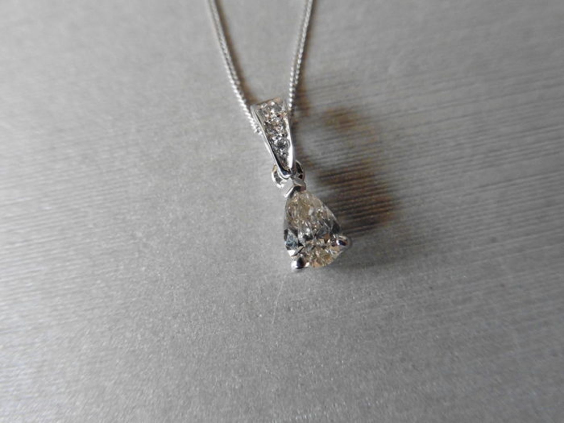 0.40ct pear shaped solitaire pendant set in platinum. J colour, si2 clarity. Diamond set bale and