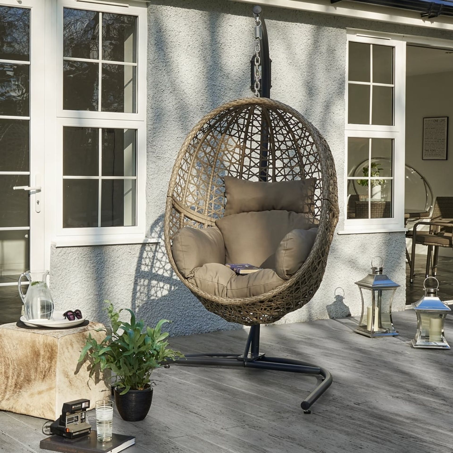 The Hove rattan pod chair with cushions and stand.