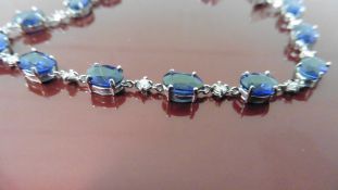 Sapphire and diamond bracelet set in 18ct gold. 14 x oval cut ( glass filled) sapphires, weighing