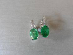 1.60ct emerald and diamond hoop style earrings. Each is set with a 7x 5mm oval cut emerald ( treated