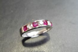 Ruby and diamond eternity band ring set in 9ct white gold. 4 small round cut rubies ( treated )0.