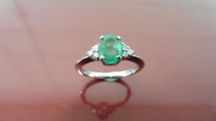 14ct white gold emerald and diamond dress ring. 0.80ct oval cut ( treated ) emerald with 3 small