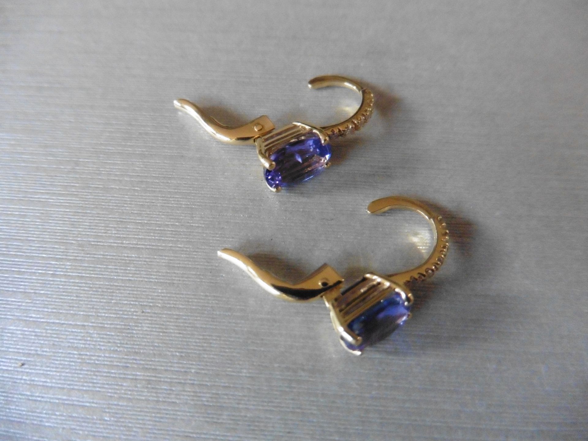 1.60ct Tanzanite and diamond hoop style earrings. Each is set with a 7x 5mm oval cut Tanzanite ( - Image 2 of 3