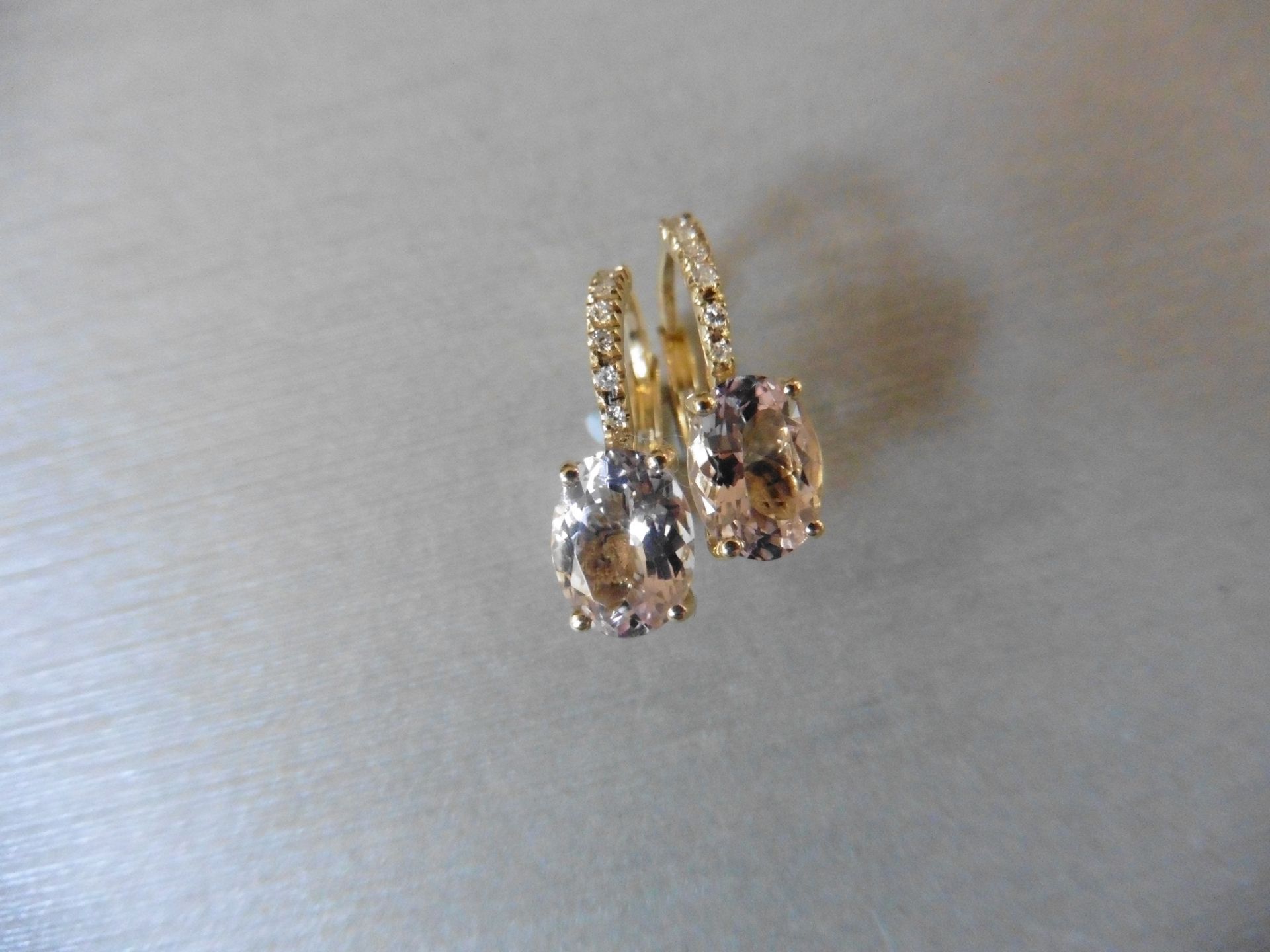 1.60ct Morganite and diamond hoop style earrings. Each is set with a 7x 5mm oval cut Morganite