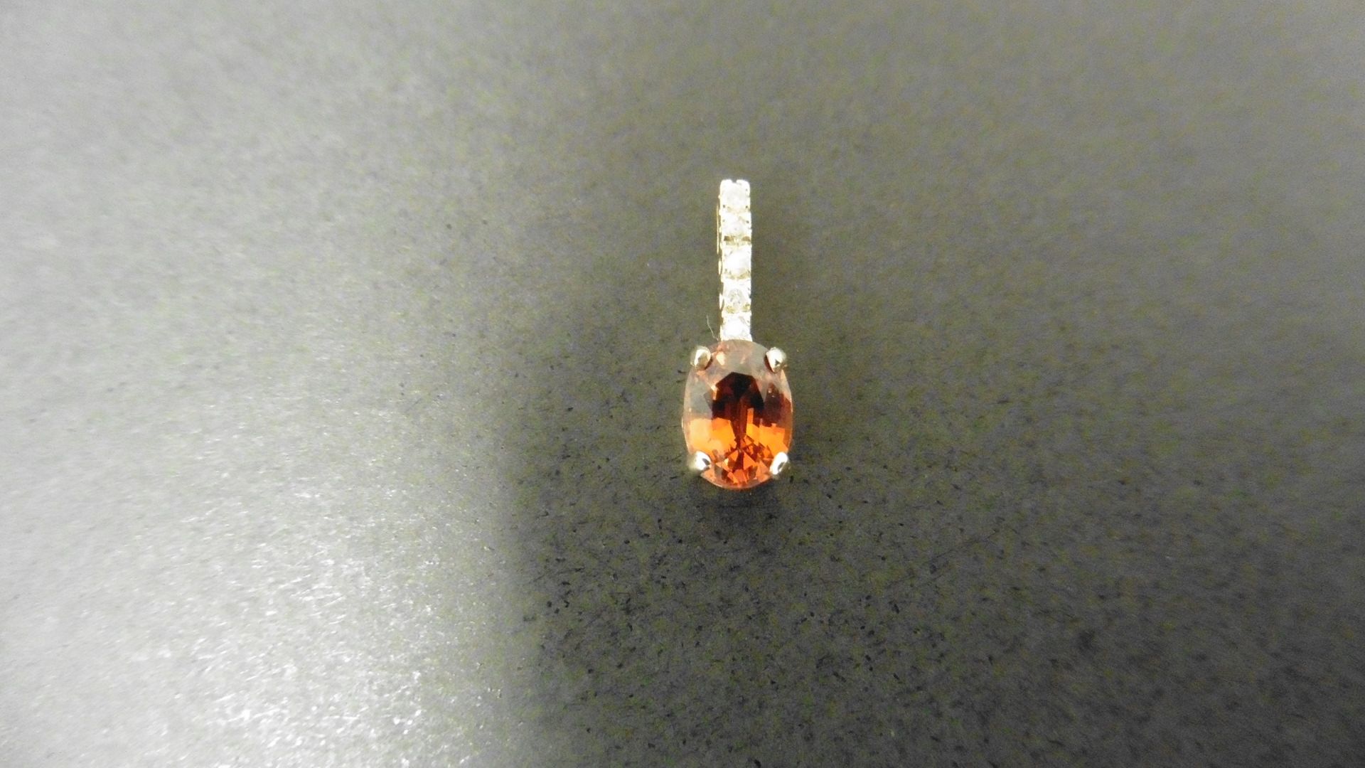 0.80ct citrine and diamond drop style pendant. 7X 5mm oval citrine set with 5 small brilliant cut