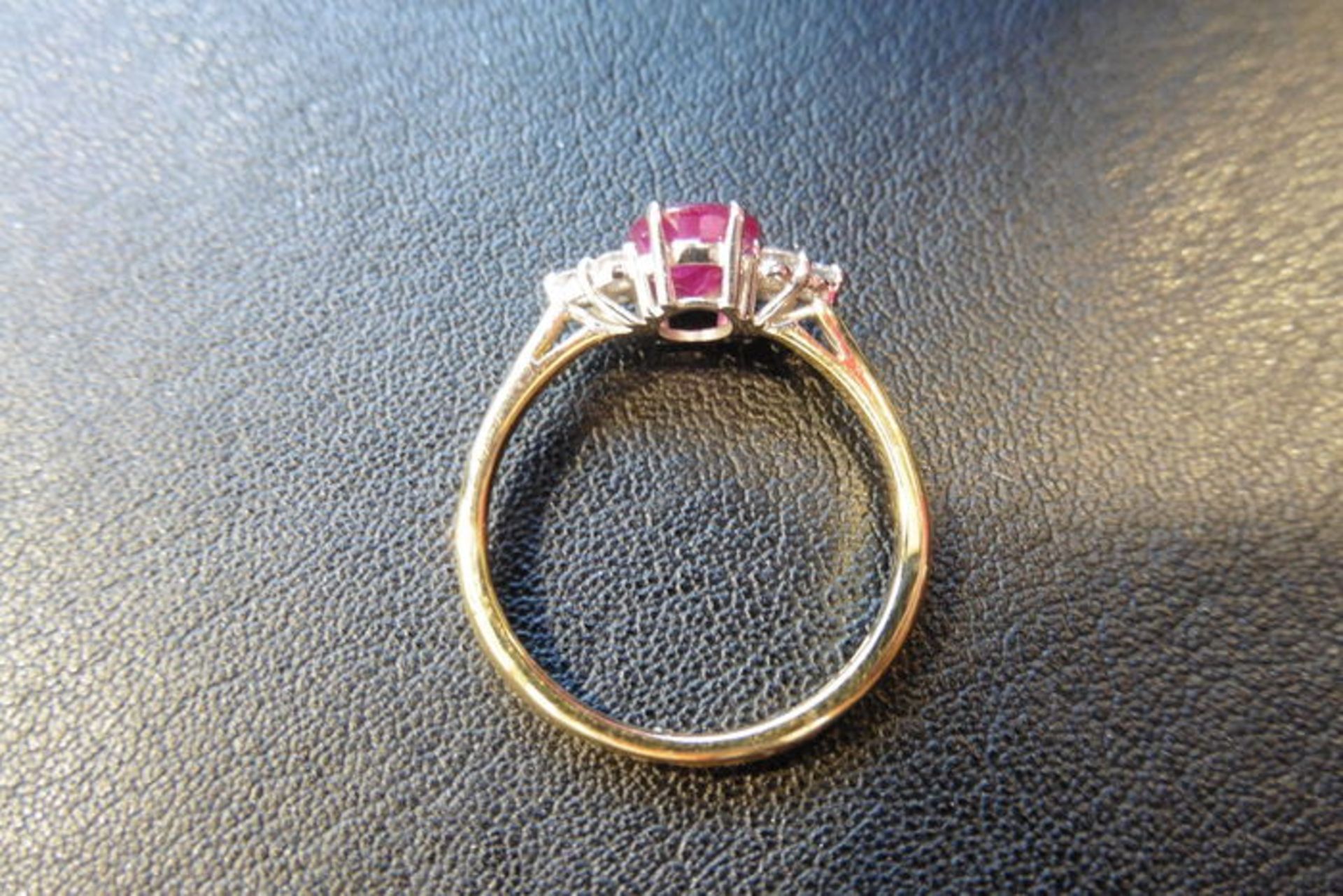 0.80ct ruby and diamond dress ring. 7x 5mm oval cut ruby (treated) with 3 small diamonds set - Image 2 of 3