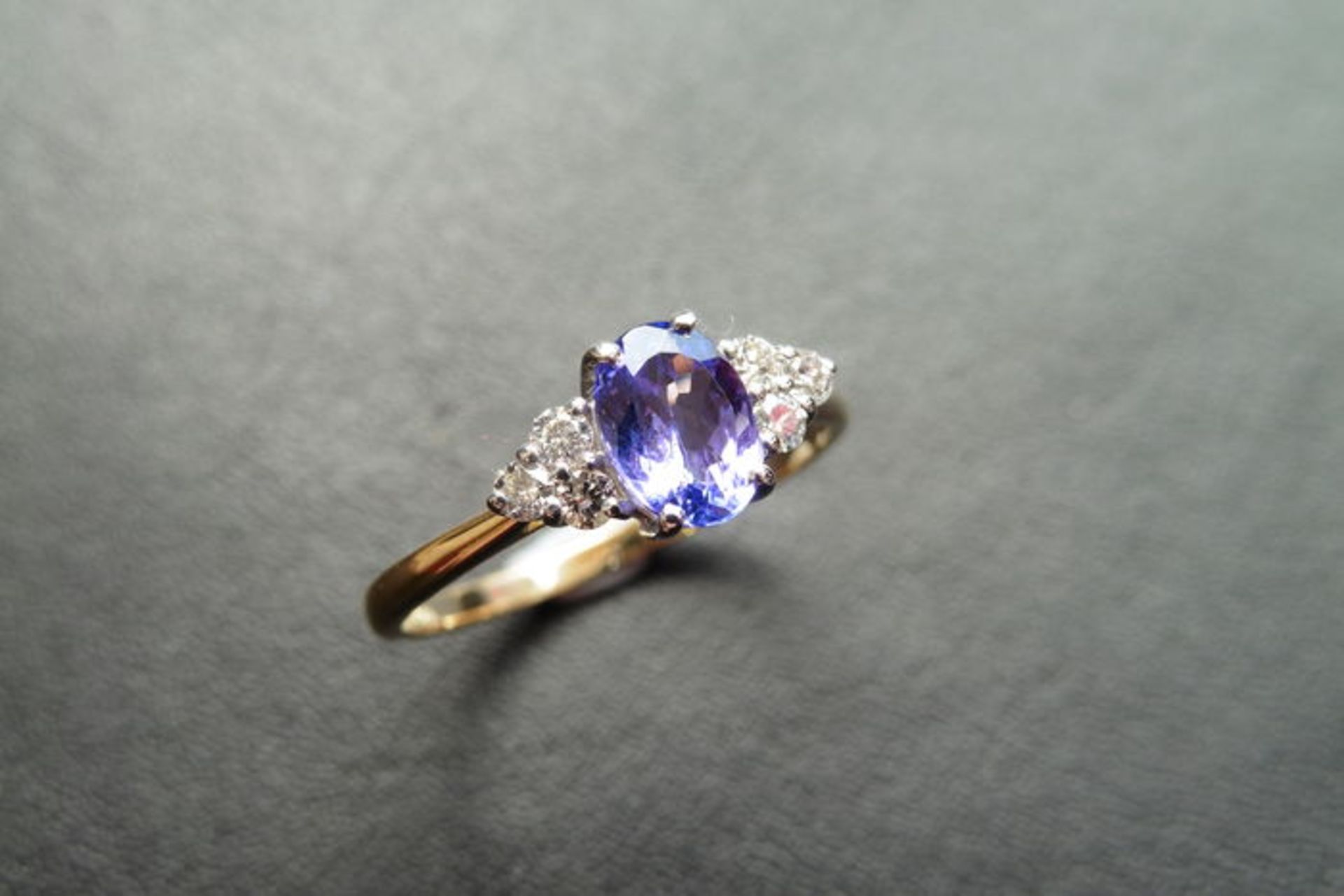 0.80ct tanzanite and diamond dress ring. Oval cut ( treated ) tanzanite with 3 small brilliant cut