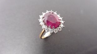 2.40ct ruby and diamond cluster ring set with a oval cut(glass filled) ruby which is surrounded by