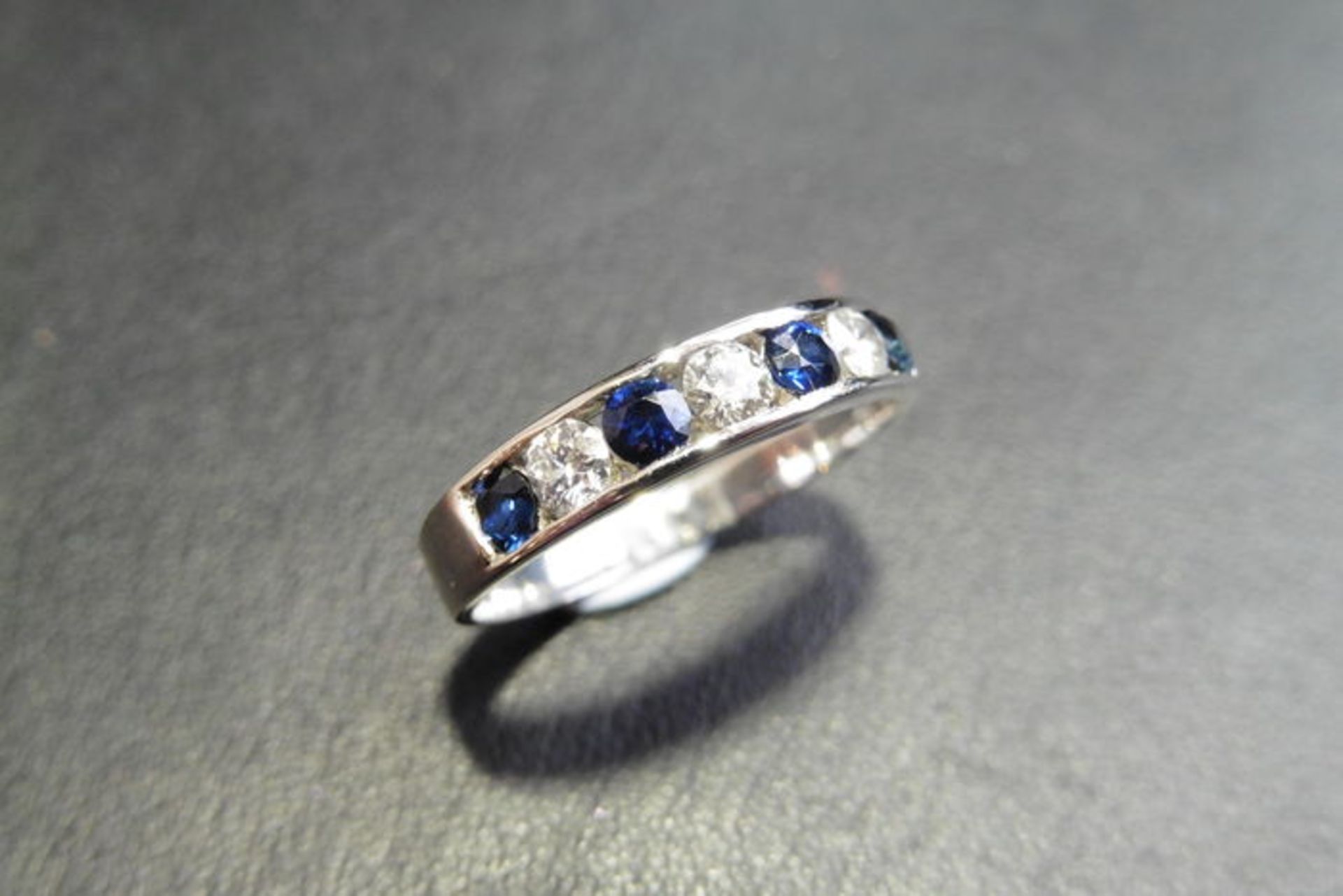 Sapphire and diamond eternity band ring set in 9ct white gold. 4 small round cut sapphires ( treated