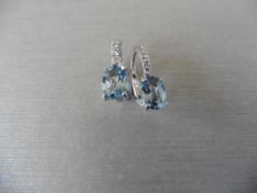 1.60ct Aqua marine and diamond hoop style earrings. Each is set with a 7x 5mm oval cut aqua (