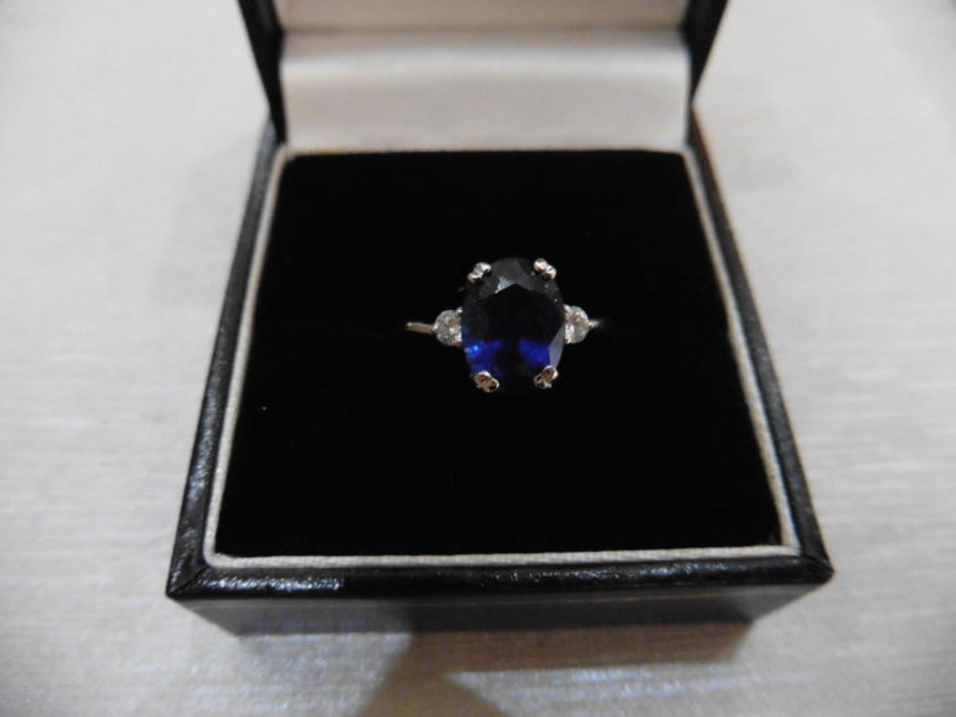 2.40ct sapphire and diamond ring. Oval cut ( glass filled ) sapphire with 2 small brilliant cut