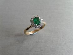 0.80ct emerald and diamond cluster ring set with a oval cut (treated) emerald which is surrounded by