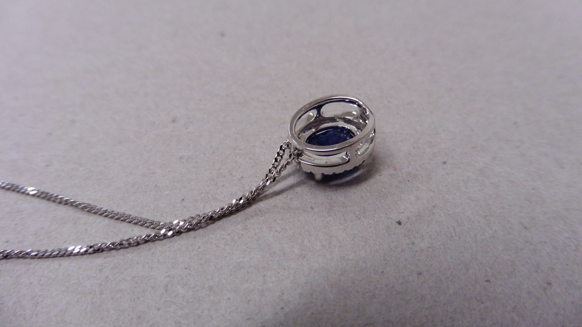 0.80ct halo set diamond pendant. Oval cut sapphire ( glass filled ) in the centre, 0.80ct, with a - Image 3 of 3