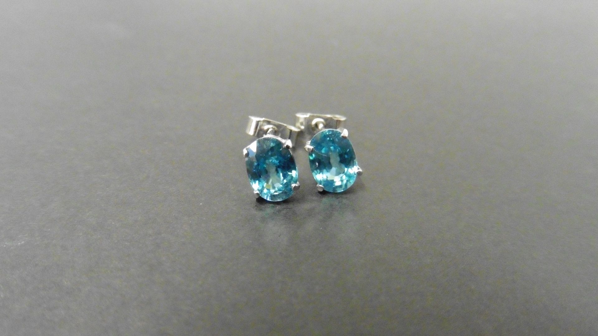 1.60ct zircon stud style earrings set in 9ct white gold. 7 x 5mm oval cut blue zircons set in a 4