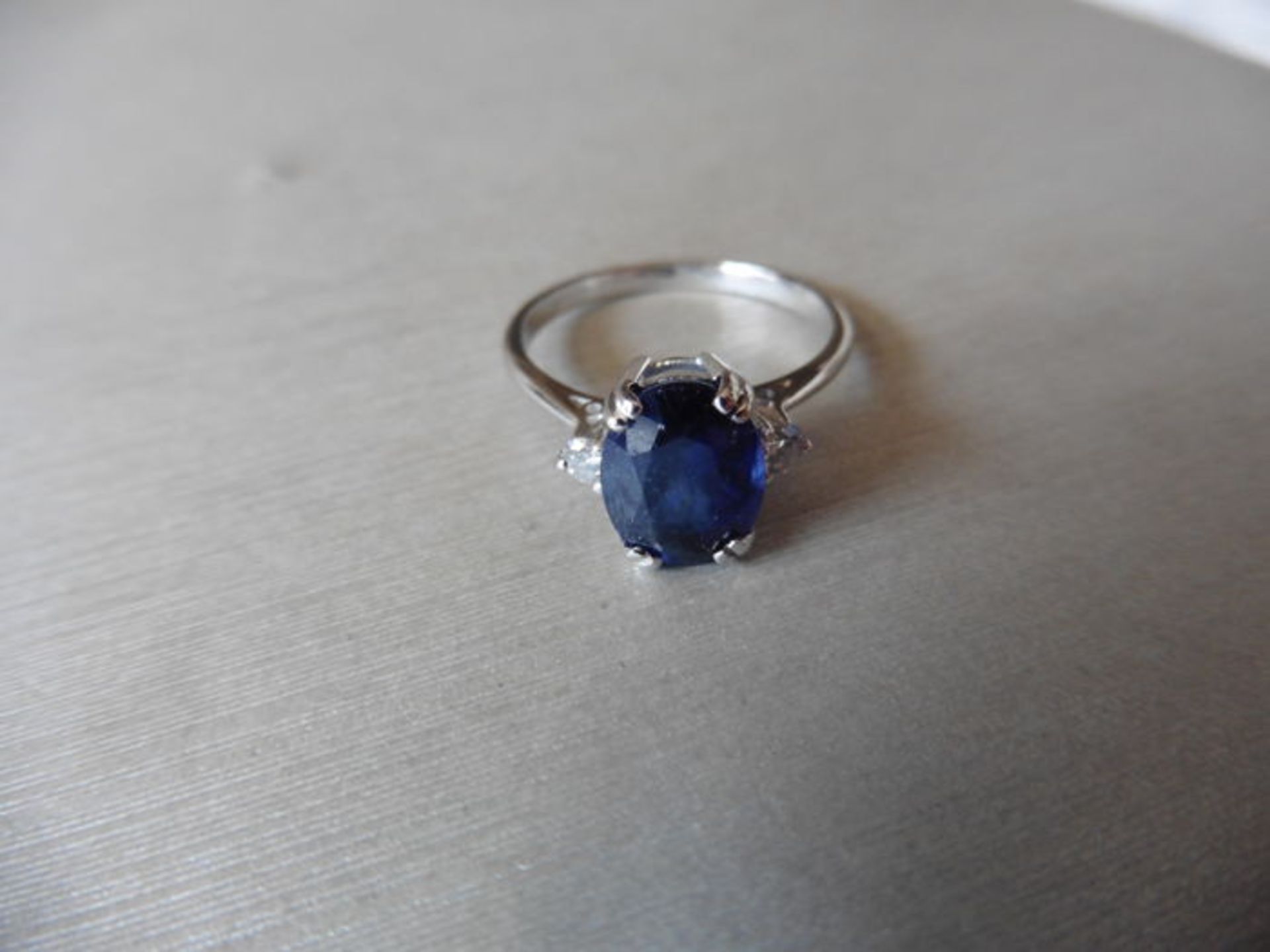 2.40ct sapphire and diamond ring. Oval cut ( glass filled ) sapphire with 2 small brilliant cut - Image 2 of 3