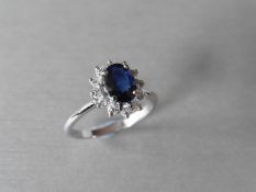 0.80ct sapphire and diamond cluster ring set with a oval cut(glass filled) sapphire which is