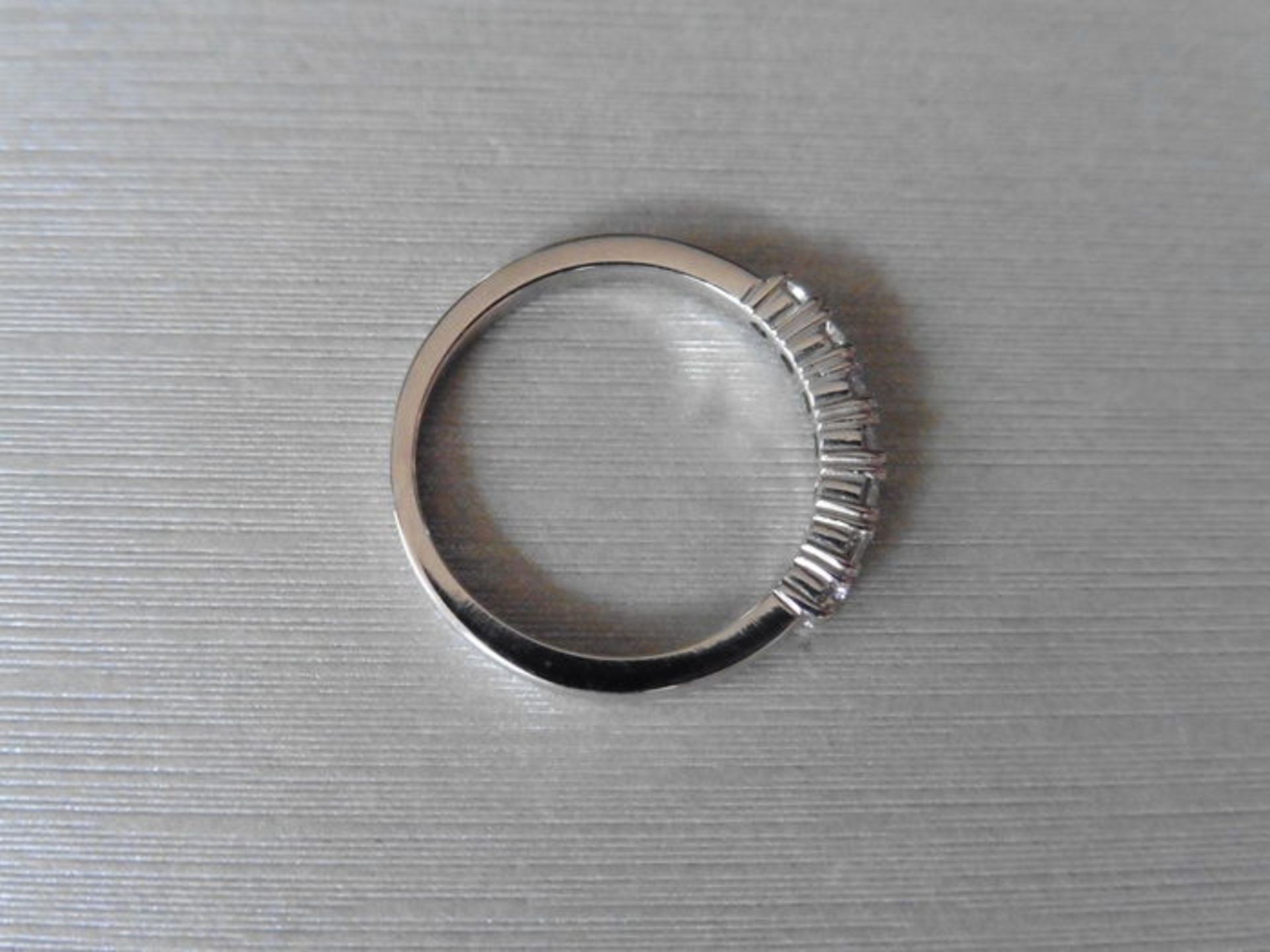 0.42ct diamond band ring set in 9ct white gold. 7 Small brilliant cut diamonds, I colour and i1
