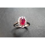 Ruby and diamond cluster style ring set in platinum. Oval cut ( treated ) ruby 0.80ct with 0.50ct of