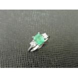 Emerald and diamond trilogy style ring. Rectangular cut emerald ( treated ) 0.70ct with a