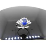 Sapphire and diamond cluster style ring set in platinum. Oval cut ( treated ) sapphire 0.80ct with