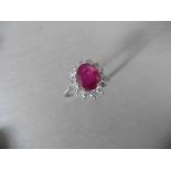 Ruby and diamond cluster style ring set in platinum. Oval cut ( glass filled ) ruby 2.50ct with 0.