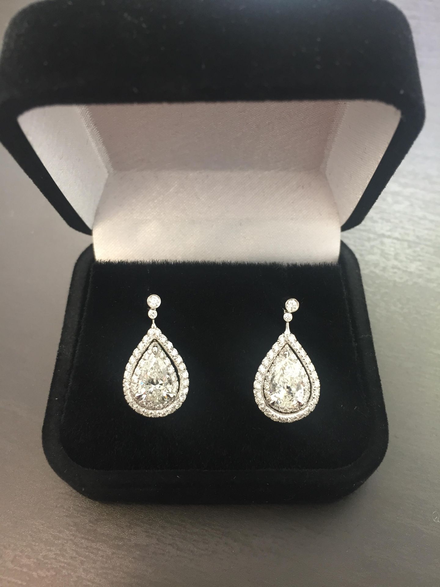 2.04ct diamond drop earrings. Each set with a certificated pear shaped diamond with a halo