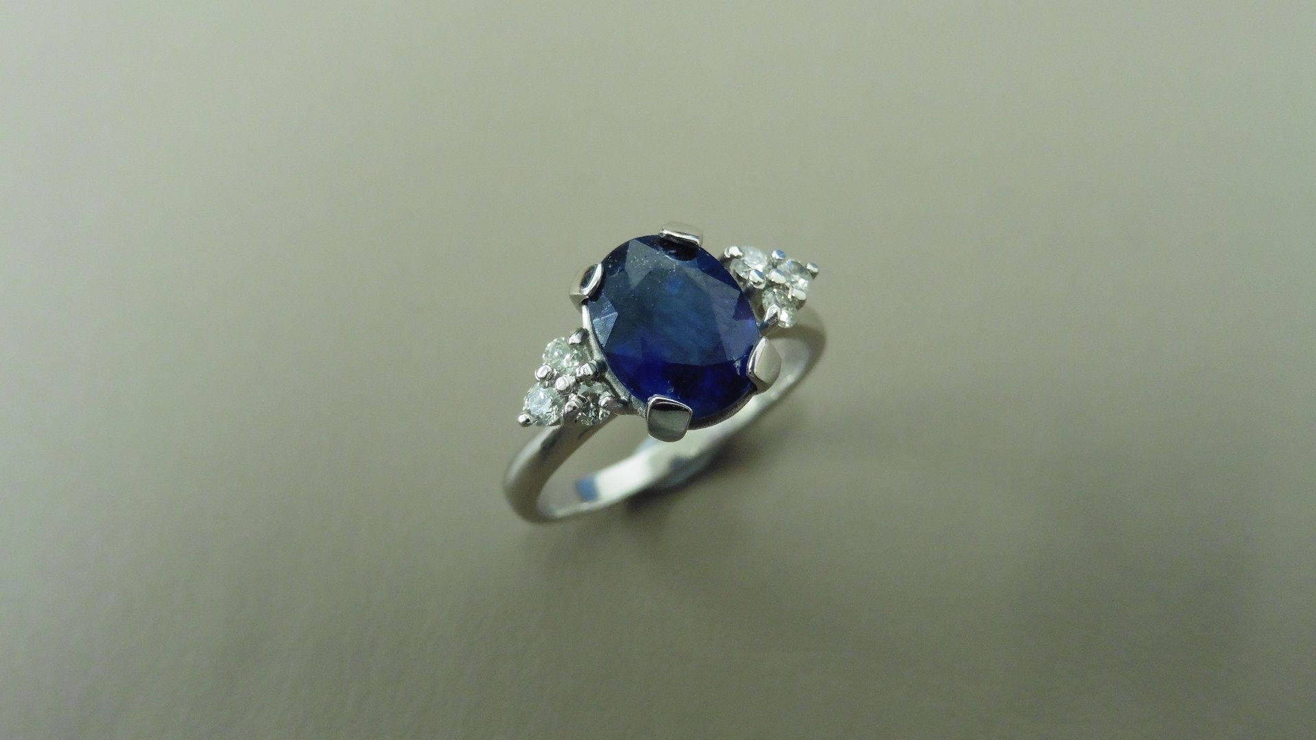 2.50ct sapphire and diamond dress ring. 9x7 oval cut ( glass filled ) with 3 small brilliant cut