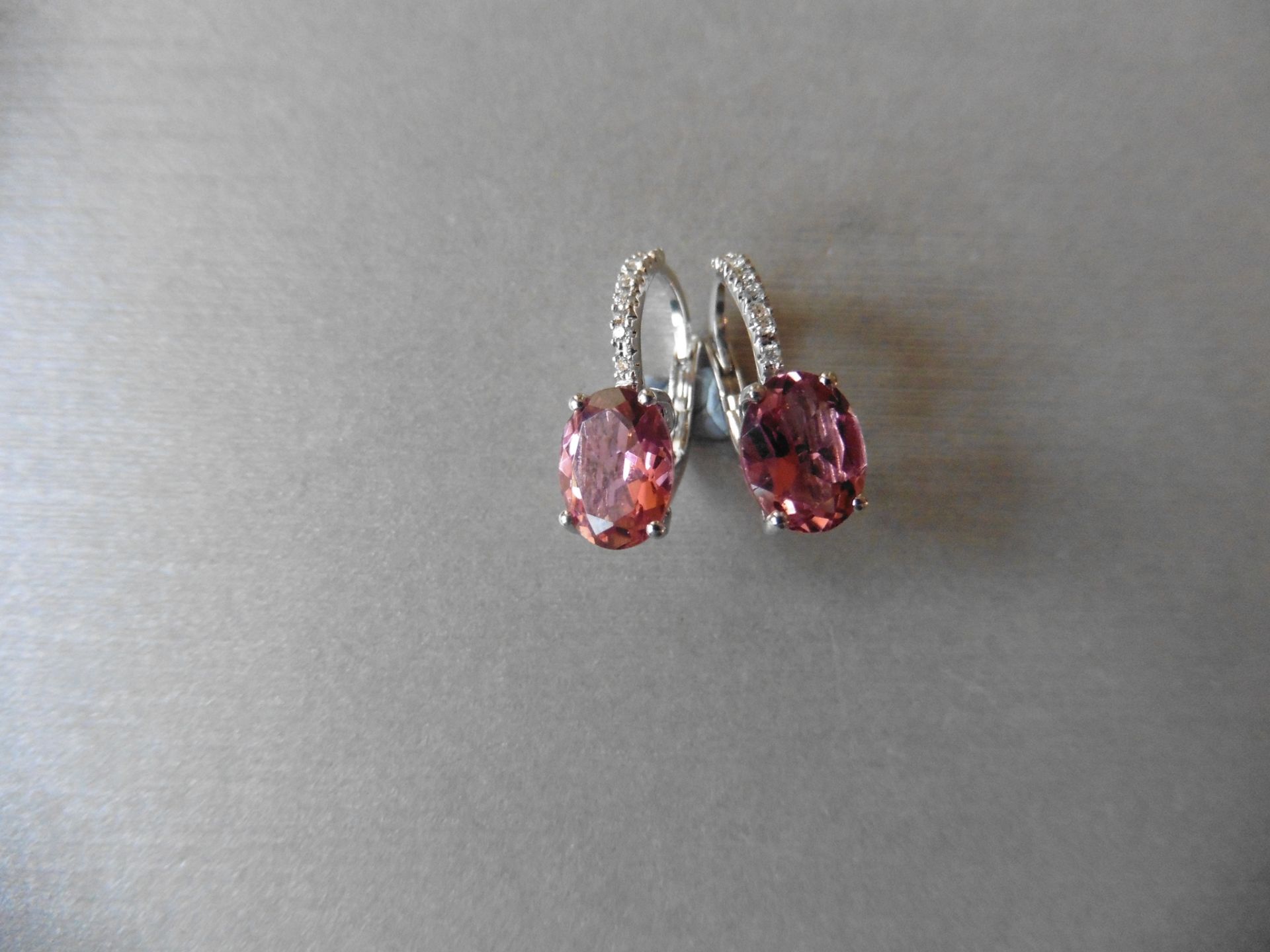 1.60ct Pink Tourmaline and diamond hoop style earrings. Each is set with a 7x 5mm oval cut