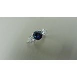 Platinum trilogy style ring. Round cut sapphire, 6mm in the centre (treated) 2 brilliant cut