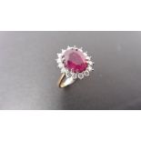 2.40ct ruby and diamond cluster ring set with a oval cut(glass filled) ruby which is surrounded by