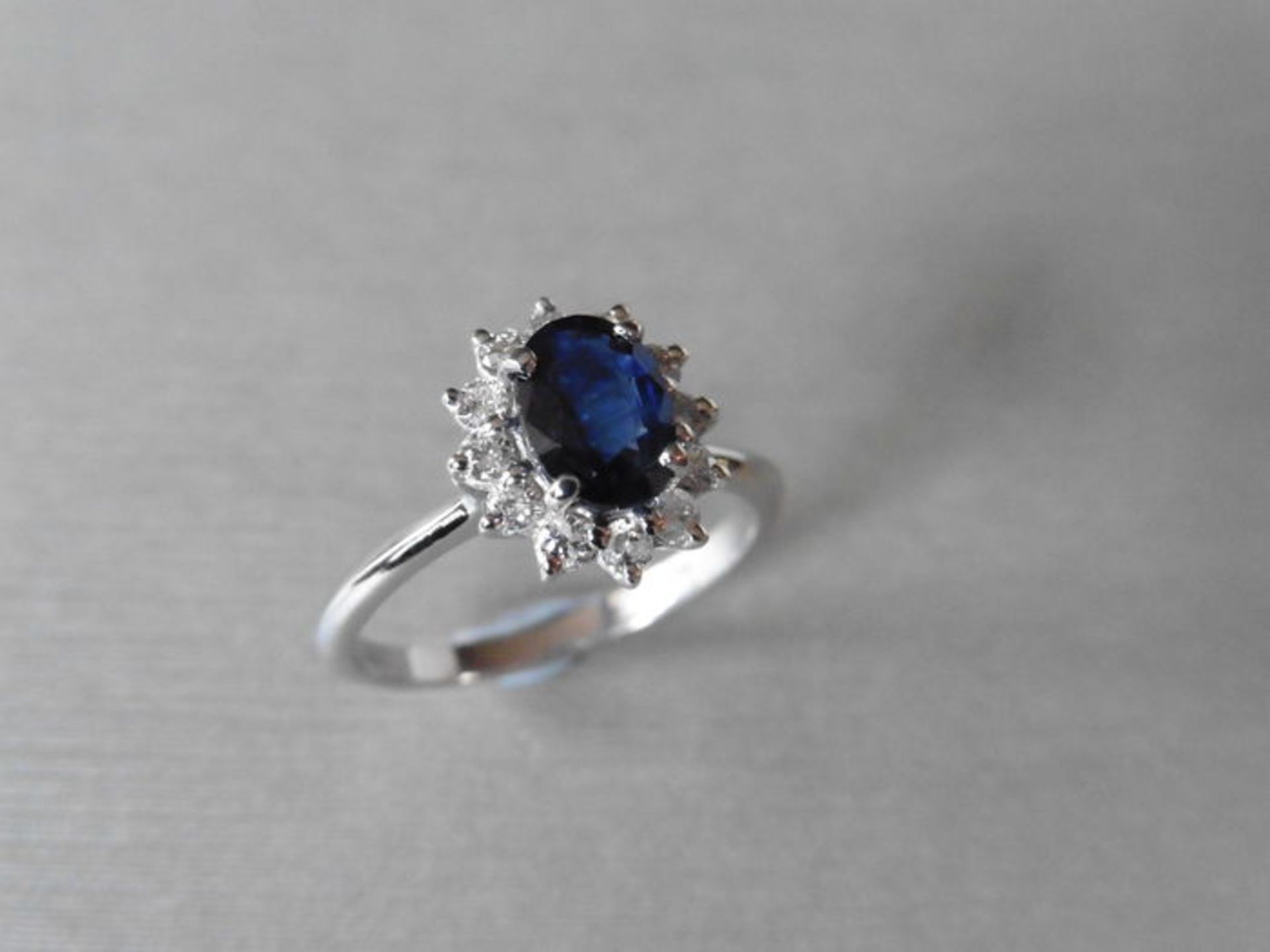 0.80ct sapphire and diamond cluster ring set with a oval cut(glass filled) sapphire which is