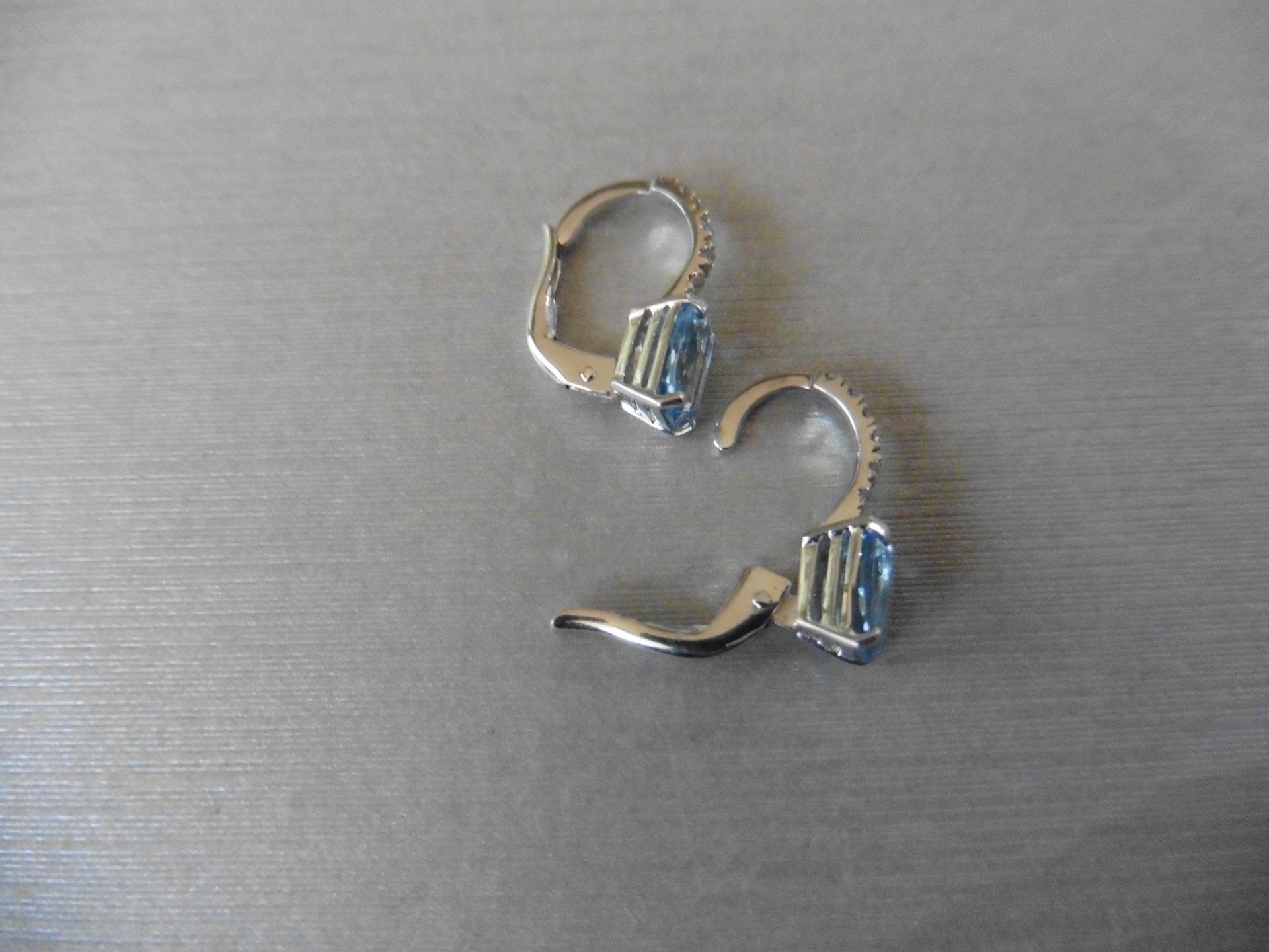 1.60ct Aqua marine and diamond hoop style earrings. Each is set with a 7x 5mm oval cut aqua ( - Image 3 of 3