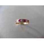 Ruby and diamond eternity band ring set in 9ct yellow gold. 4 small round cut rubies ( treated ) 0.