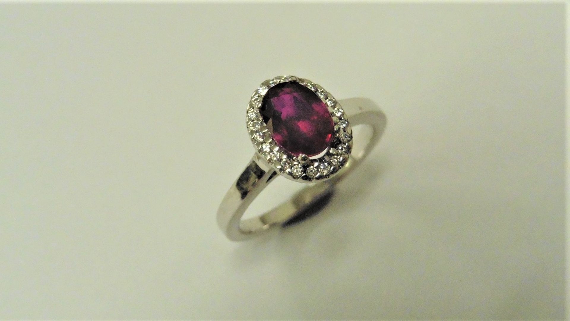 Ruby and Diamond cluster ring set in platinum. Oval cut ruby ( fracture filled ) 1ct, surrounded