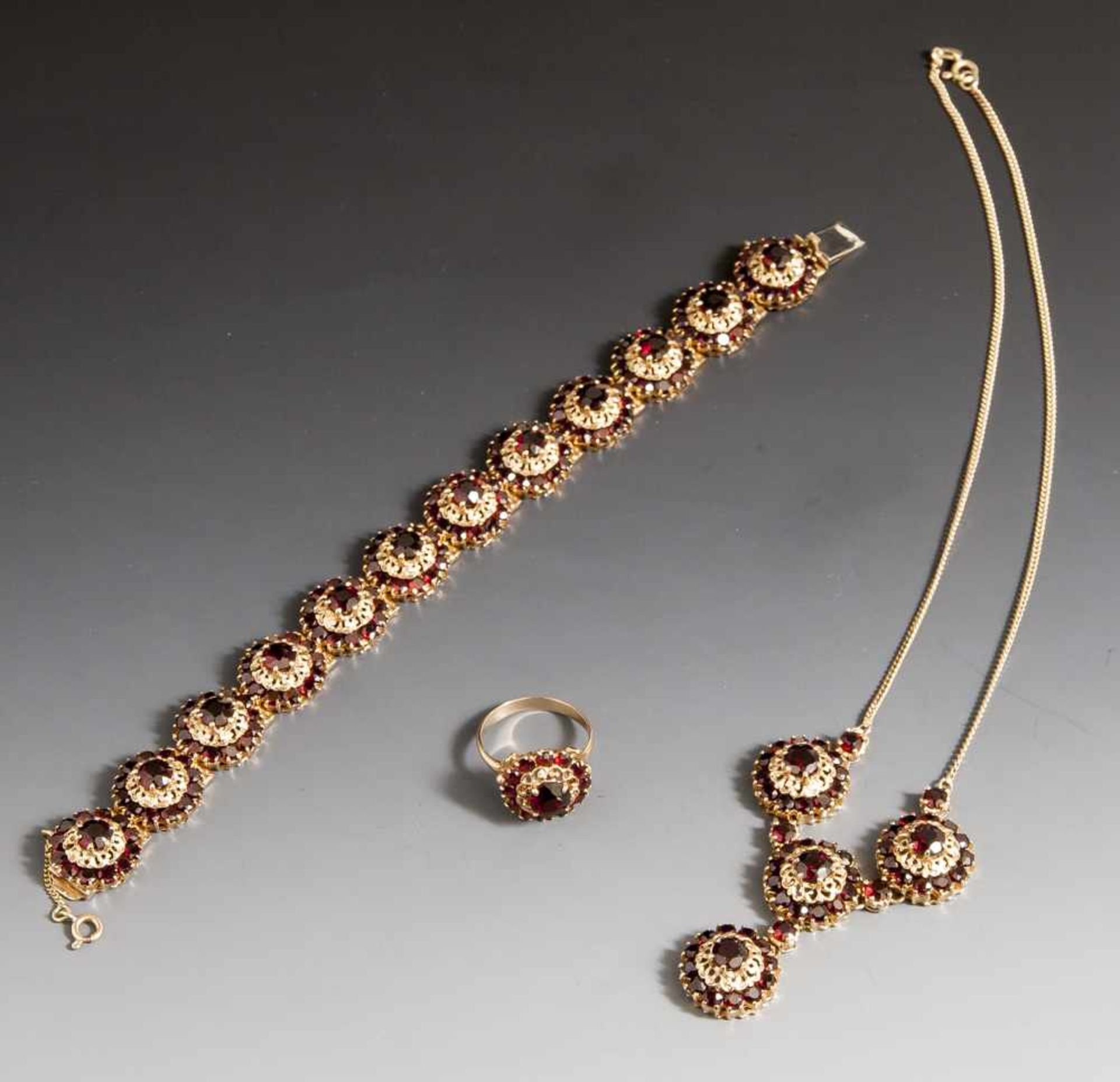 3-teiliges Schmuckset, Collier, Armband und Ring, Gelbgold 585 mit Granatenbesatz. Aufwendige